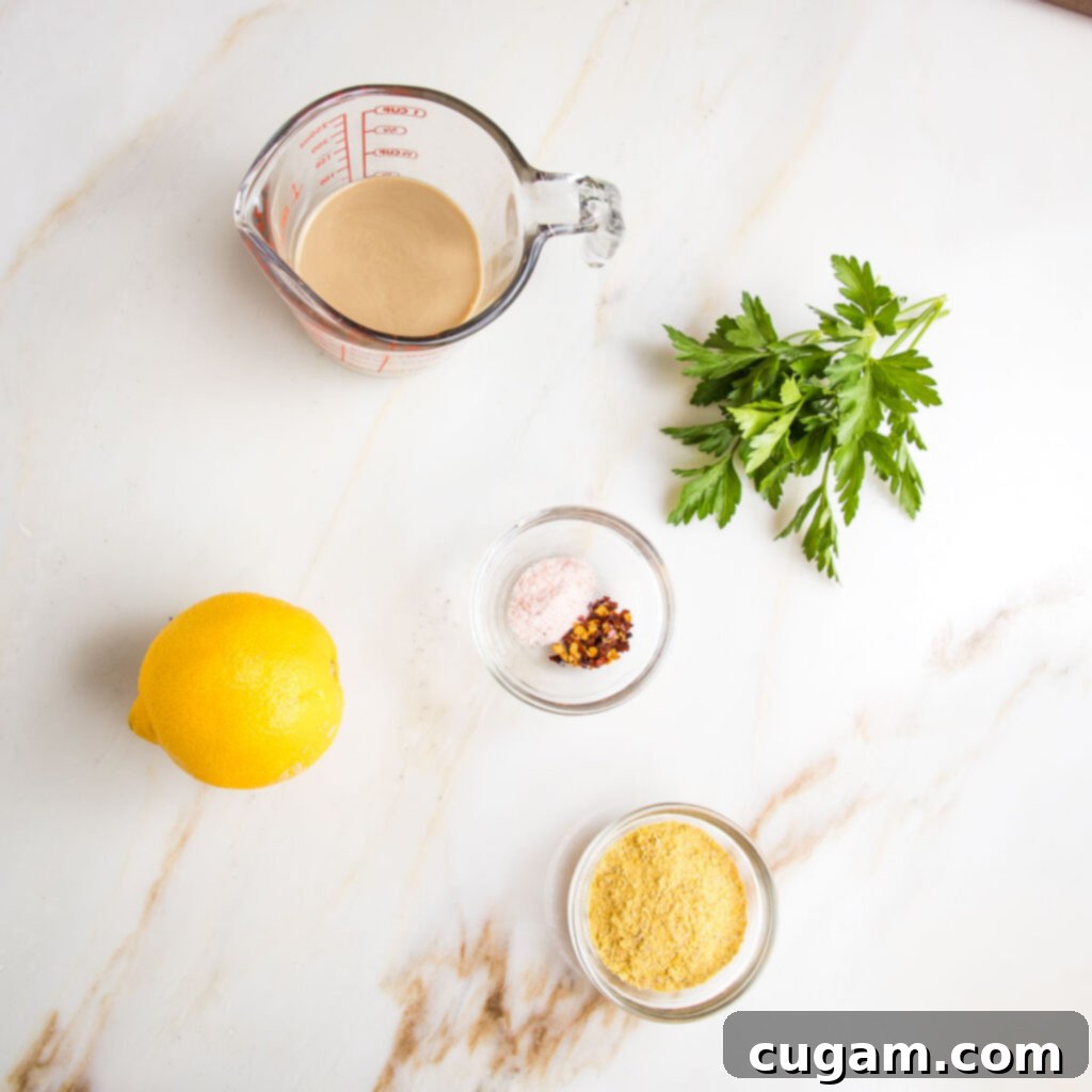 Ingredients laid out for pasta sauce: tahini, lemon, salt, pepper, nutritional yeast, fresh parsley