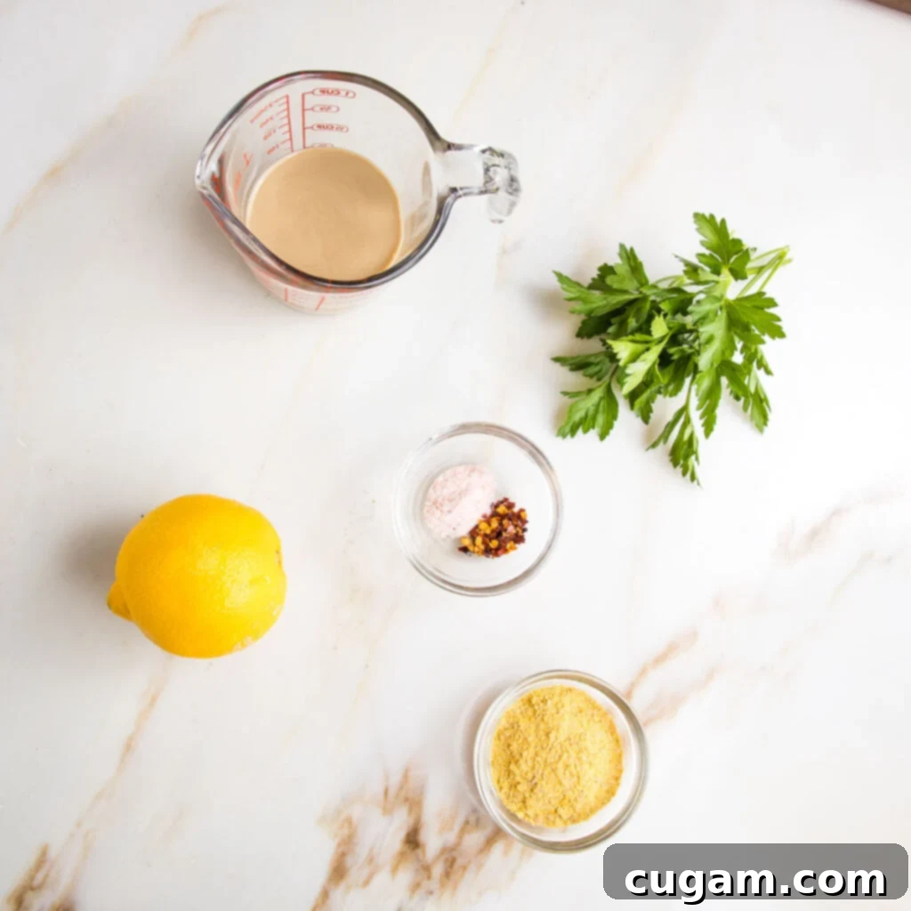 Ingredients laid out for pasta sauce: tahini, lemon, salt, pepper, nutritional yeast, fresh parsley