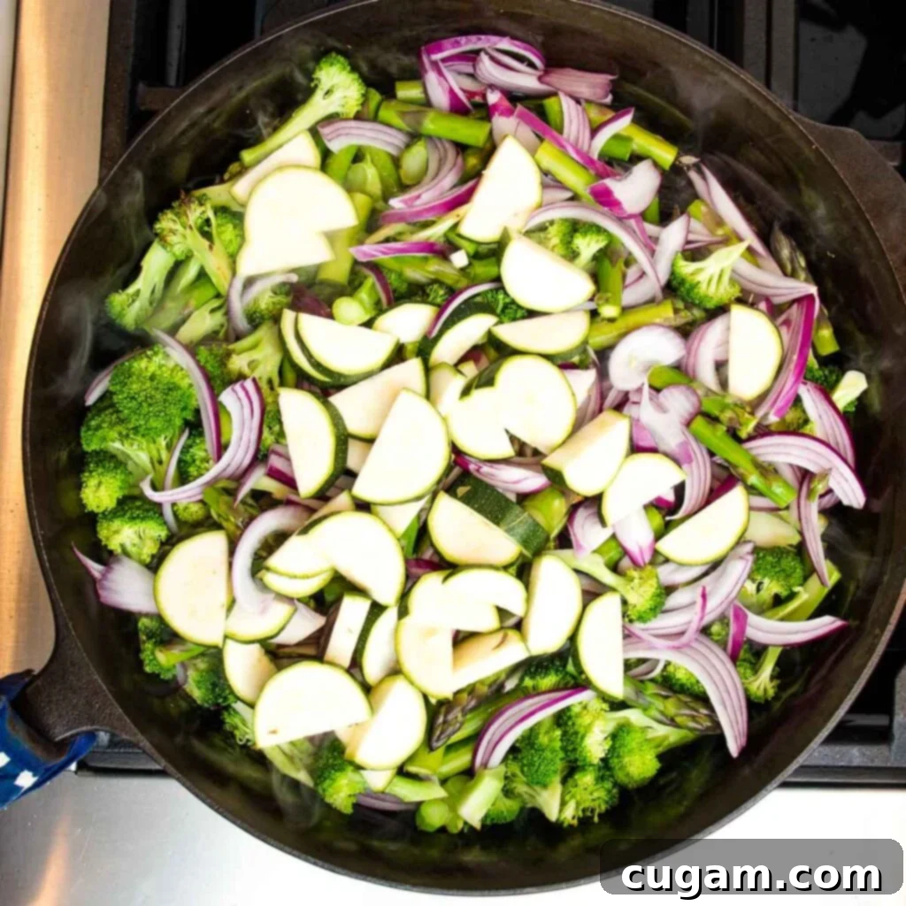Zucchini and red peppers added to the skillet.