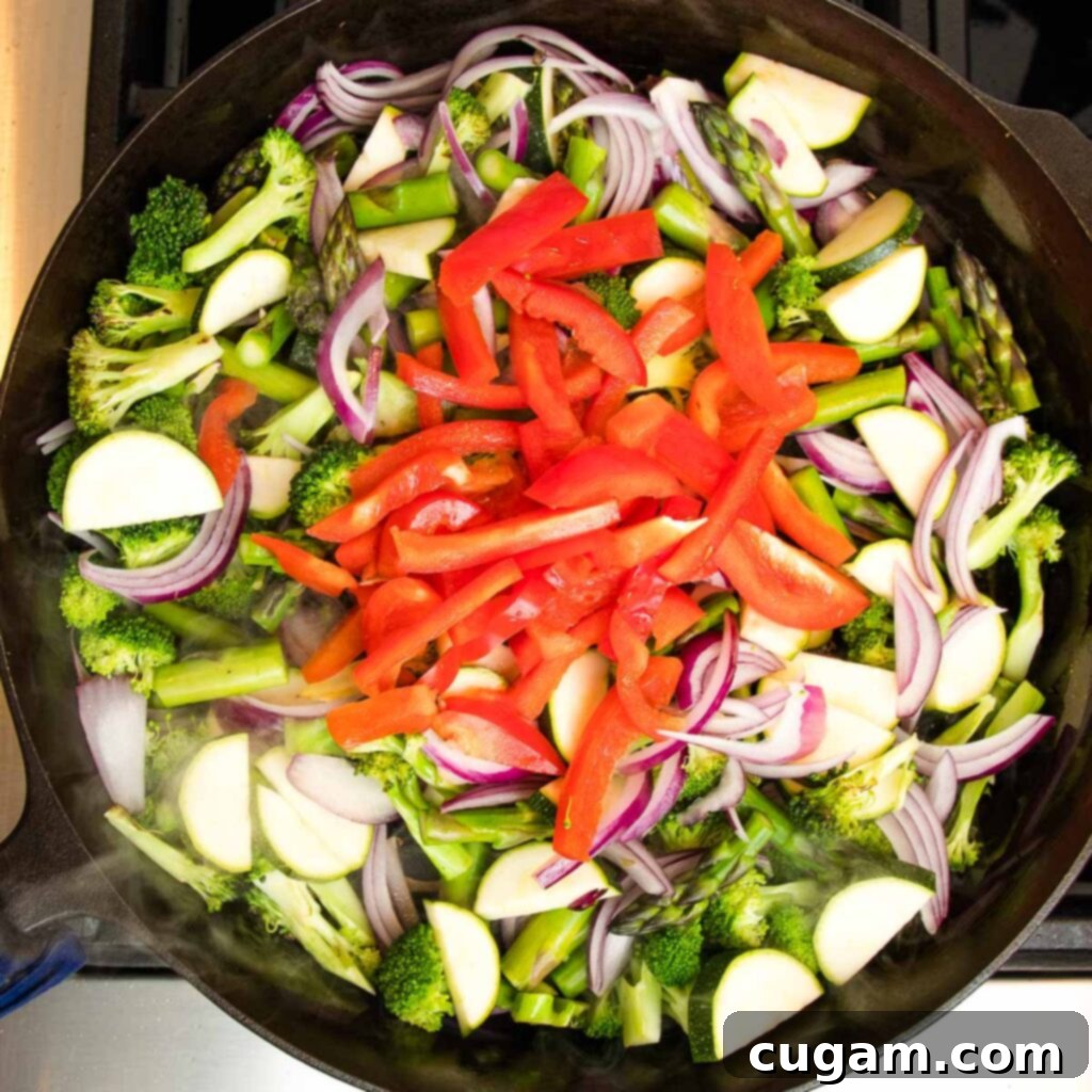 More vegetables sautéing with liquid.