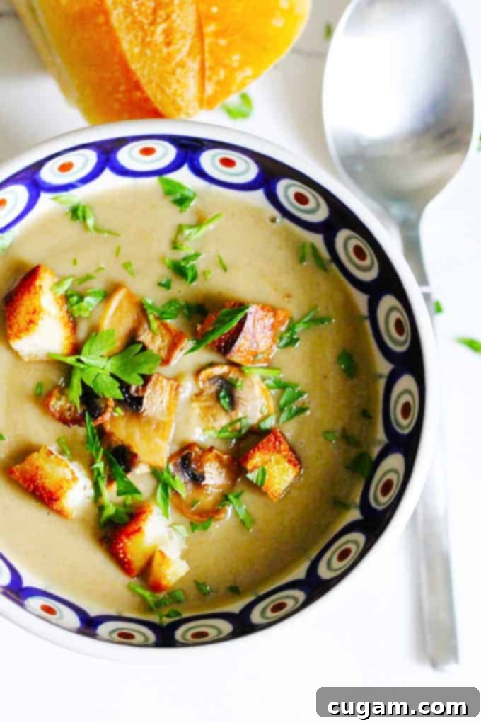 Creamy mushroom soup with croutons in a blue bowl