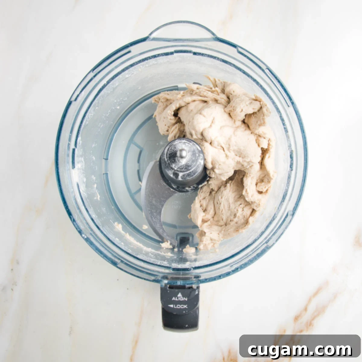No yeast flatbread dough roughly mixed in the bowl of a food processor.