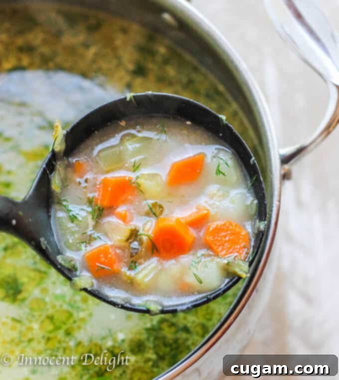 Polish Dill Pickle Soup simmering in a large pot with a ladle