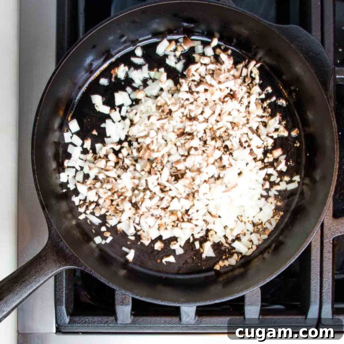 Cast iron skillet with diced mushrooms and onions.