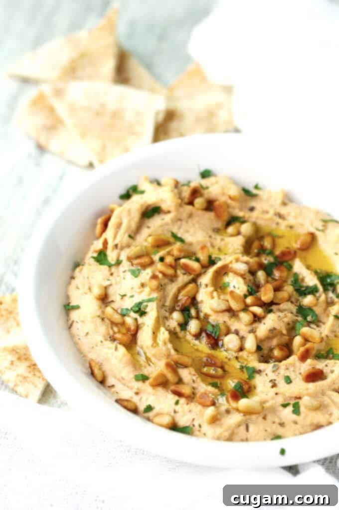 Freshly blended Chipotle Hummus in a food processor, showcasing its creamy texture before being transferred to a serving bowl.