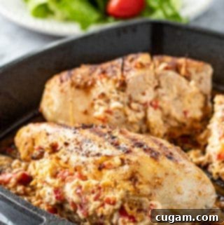 Cooked Pepperjack stuffed chicken breast in cast iron pan, sliced to show creamy filling.