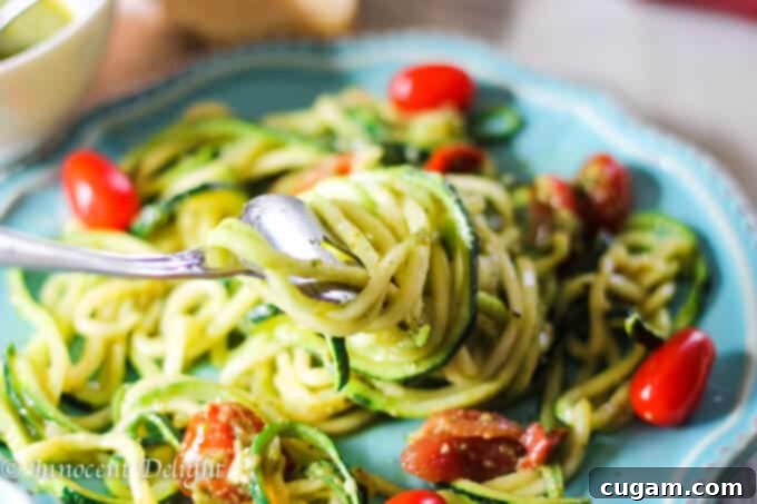 Fresh Pesto Zucchini Noodles with vibrant Cherry Tomatoes, ready for a delicious summer meal.