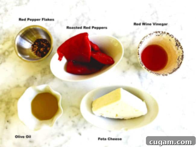 A flat lay photograph showcasing all the fresh and simple ingredients required to make the homemade Spicy Feta Dip, including feta cheese, red peppers, and olive oil.