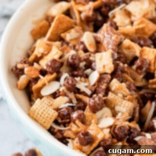 A blue bowl filled with a delicious mix of cereals, slivered almonds, and toasted coconut, ready for the gooey chocolate coating.
