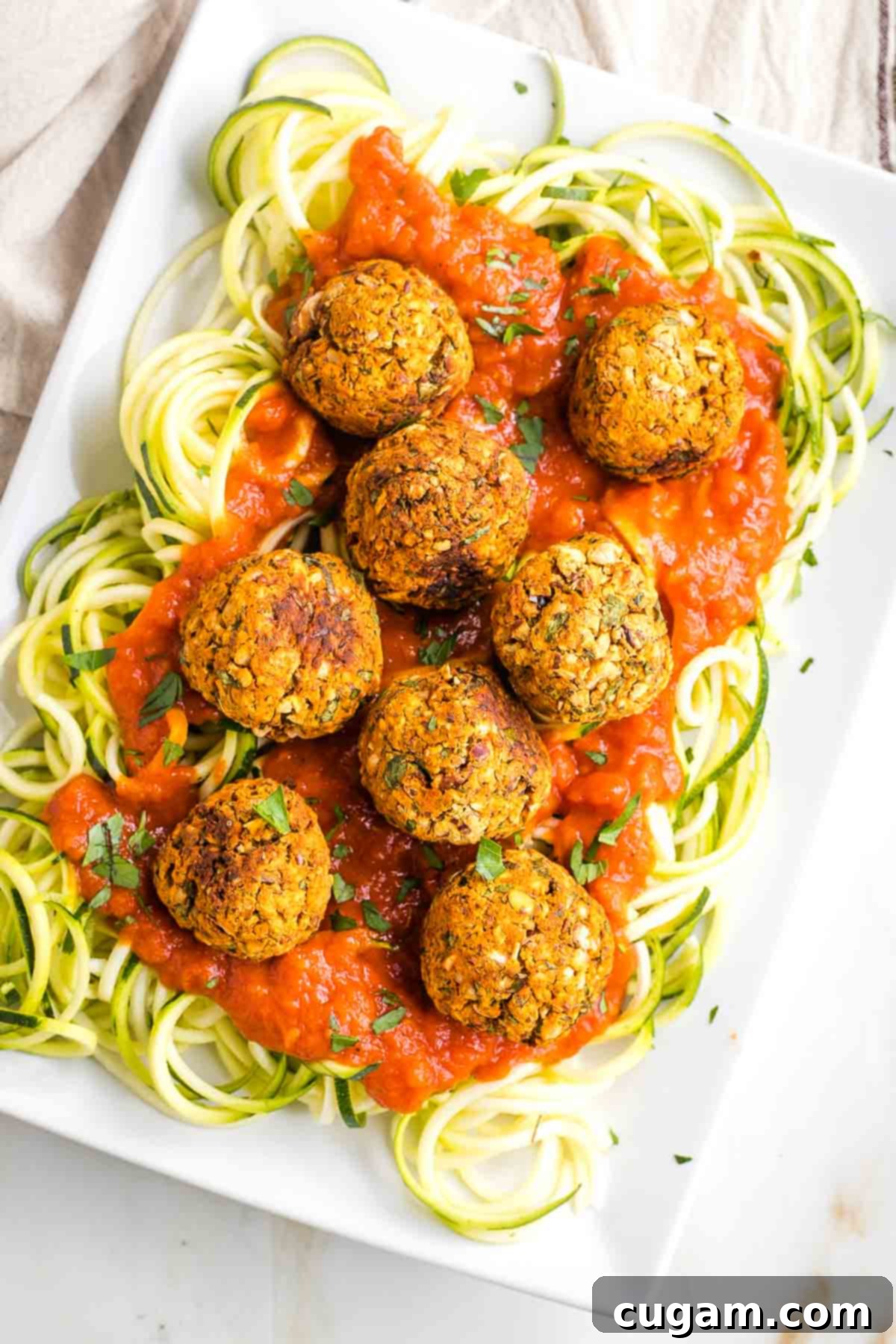 Platter filled with zucchini noodles, marinara and plant based meatballs.