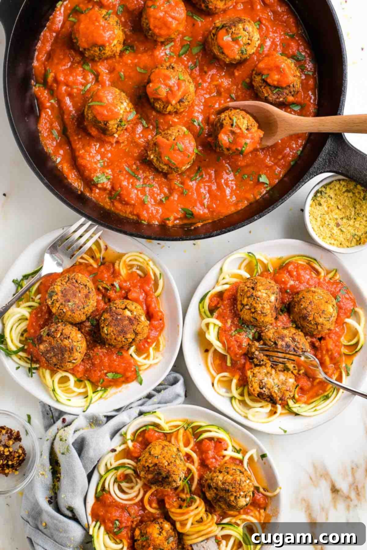 Vegan meatballs in tomato sauce, served on plates with zucchini noodles.