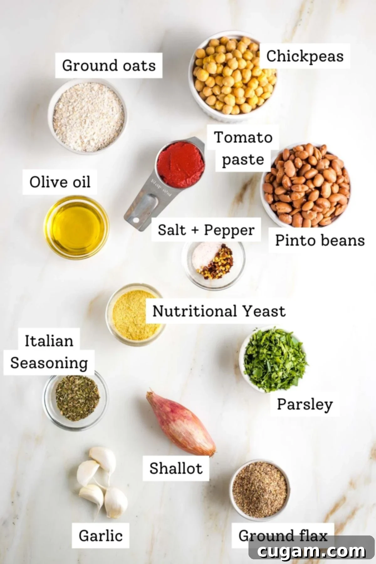 A collection of fresh ingredients for vegan meatballs, including various beans, herbs, and spices, laid out on a wooden surface.