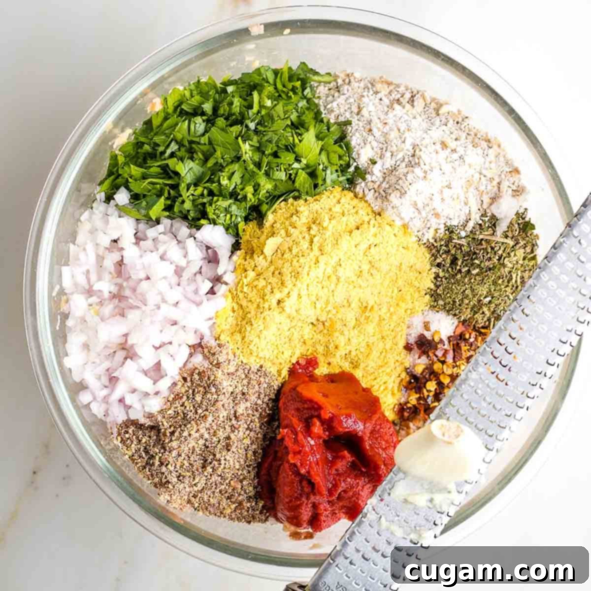 Adding all remaining ingredients to the mashed beans in a large mixing bowl.