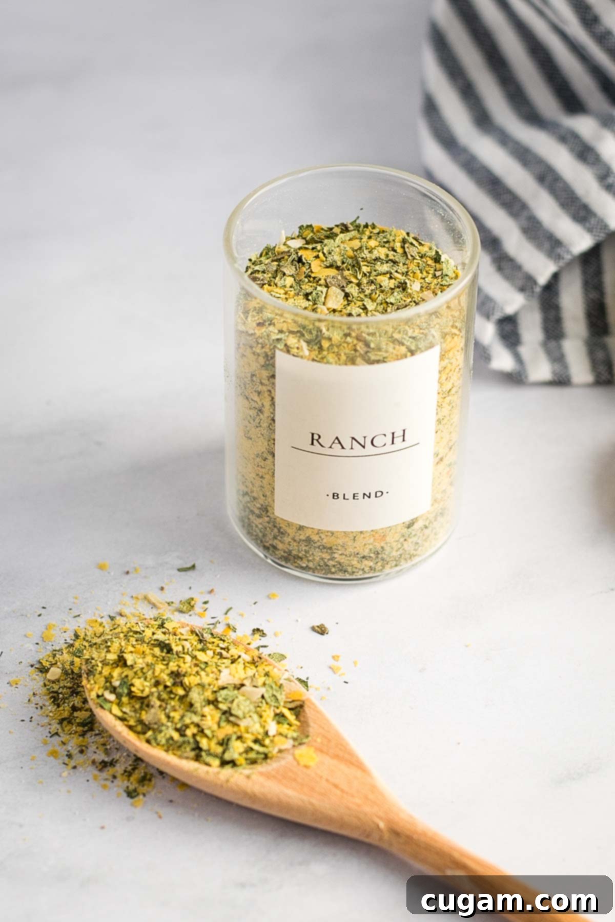 Small spice jar with a label "ranch blend" filled with dried herbs and spices, showcasing the neatly stored homemade mix.
