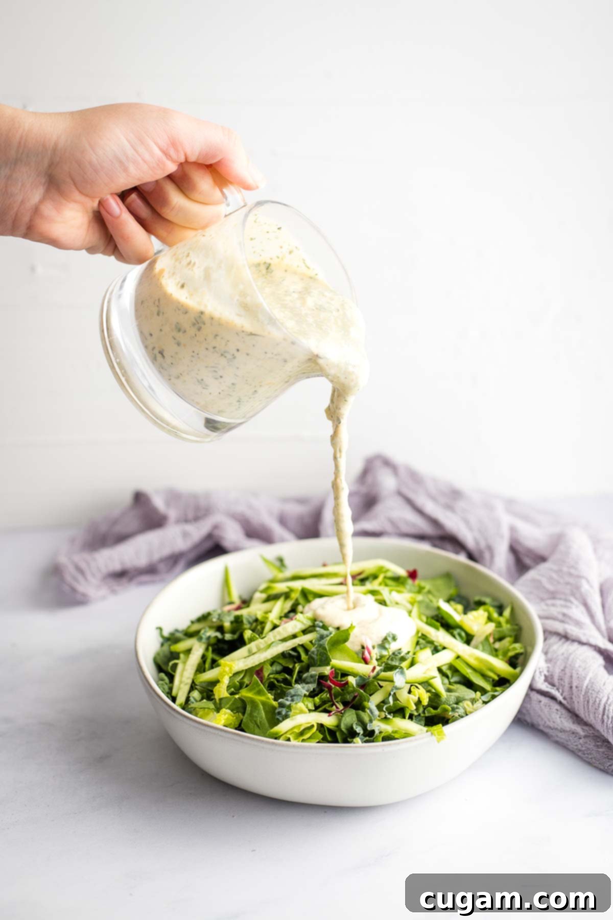 A vibrant, fresh salad generously topped with homemade dairy-free ranch dressing, showcasing the perfect consistency and delicious appeal of the dressing.