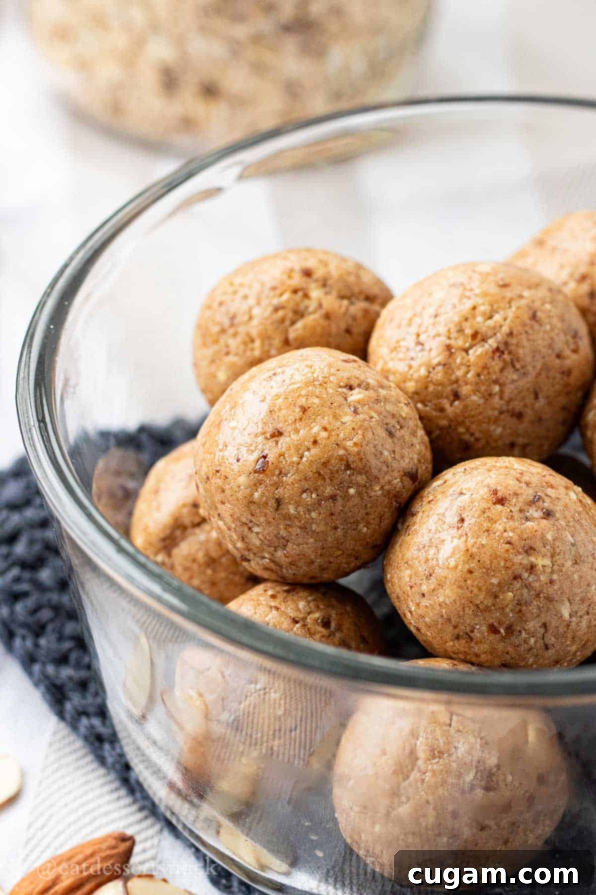 Almond butter protein balls stacked in glass bowl.