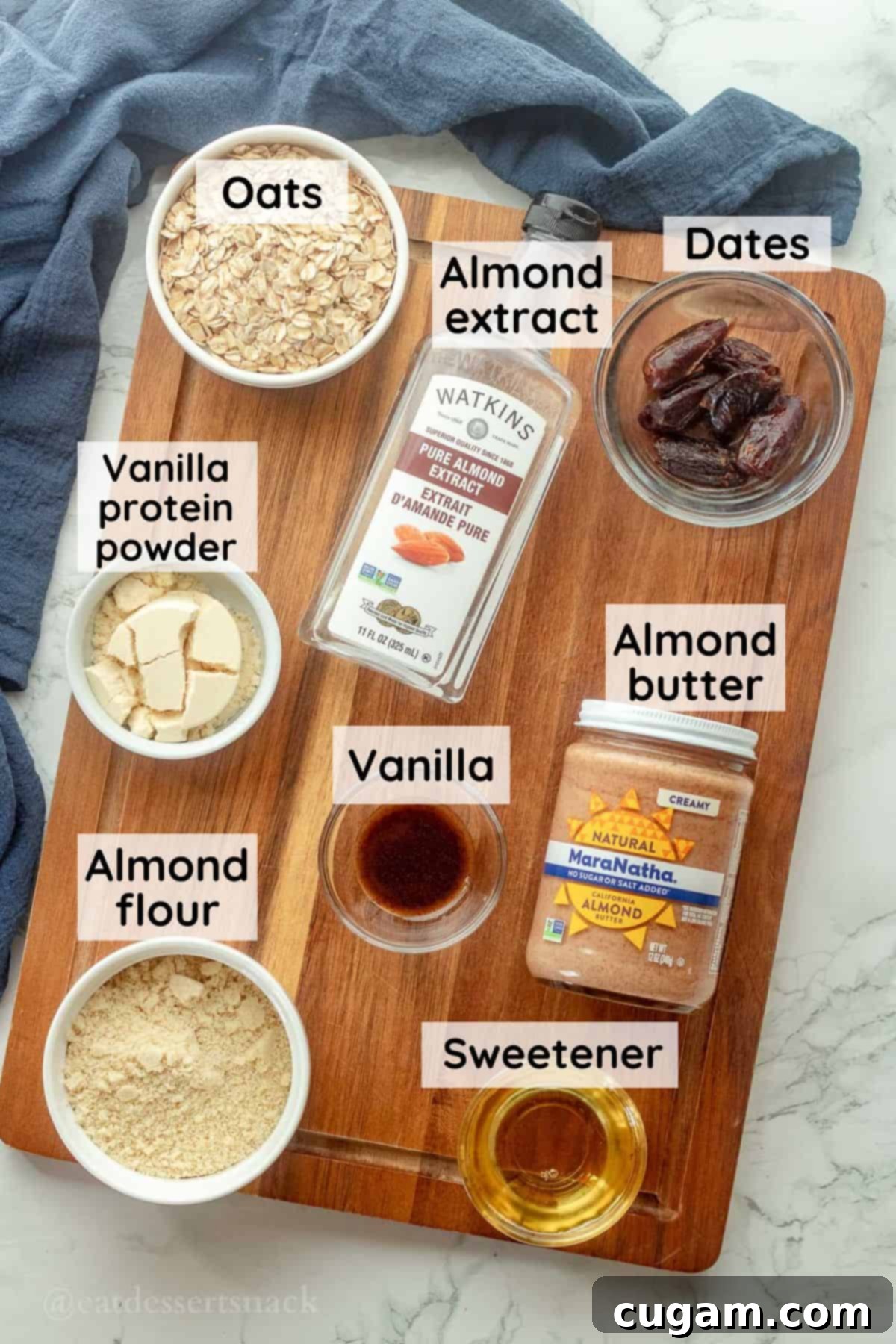 Ingredients for almond butter protein balls in glass bowls on wood cutting board.