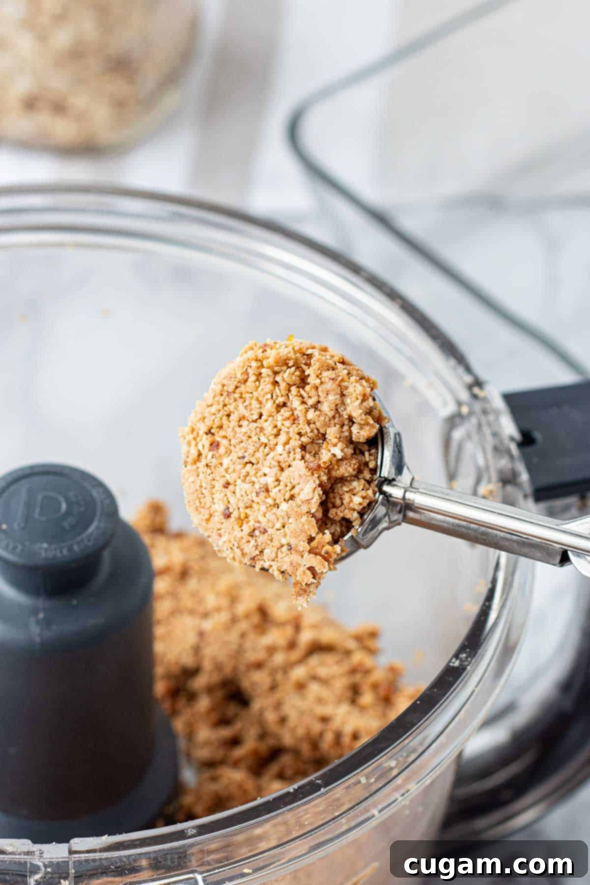 Scoop of almond butter protein dough in metal cookie scoop.