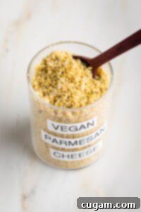 Small glass spice jar filled with vegan parmesan cheese.