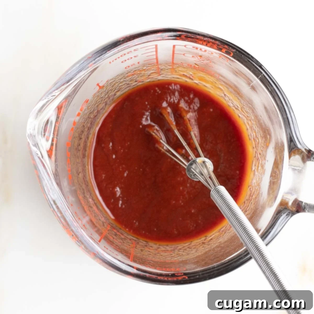 Whisking tomato paste, tamari, and water.