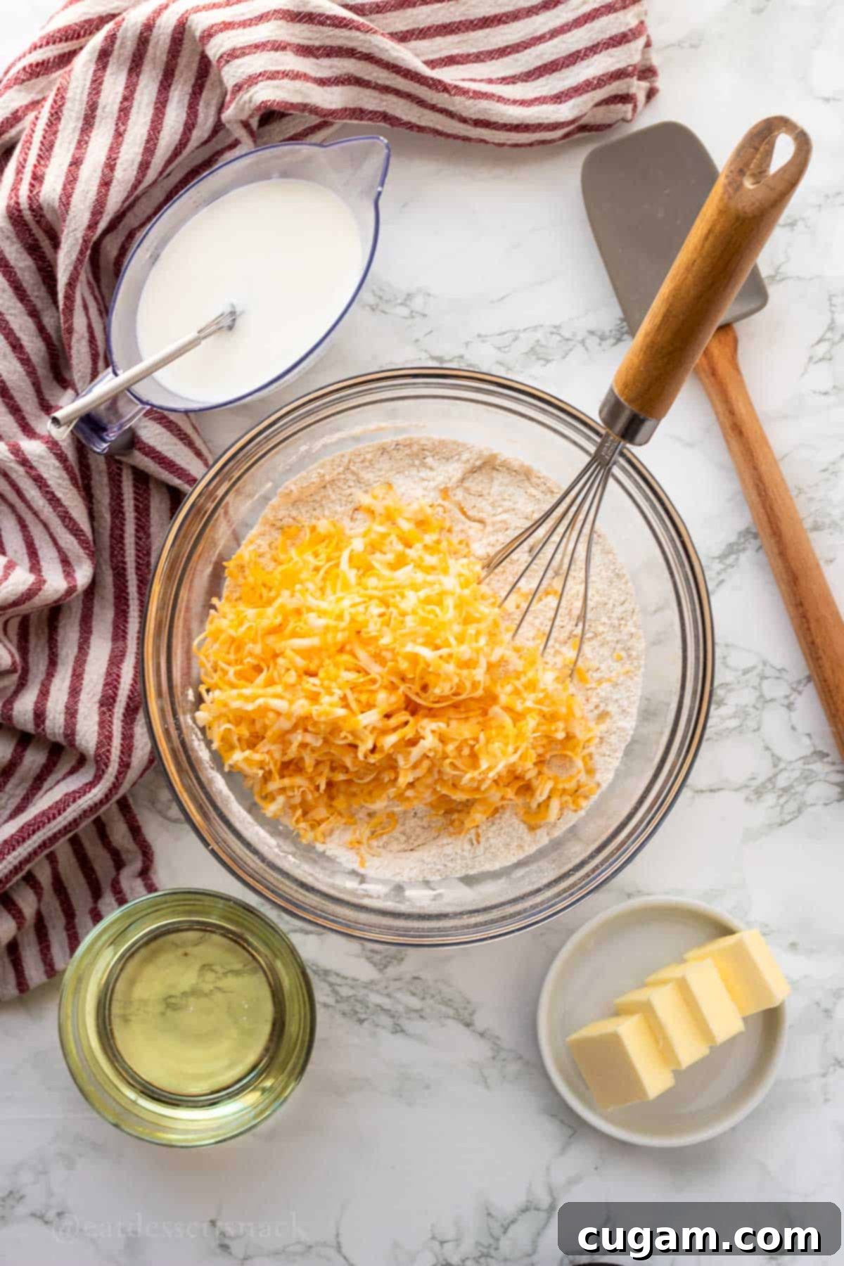 Shredded cheese and dry ingredients in glass bowl.