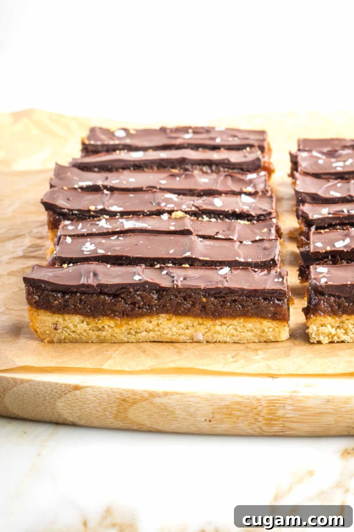 Cutting board with homemade twix, sliced into bars.