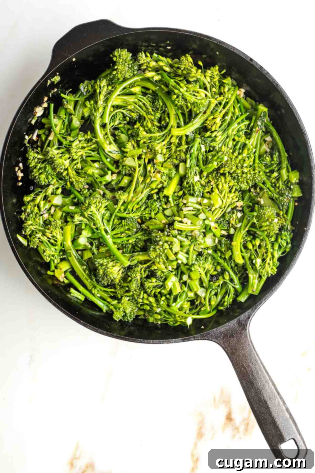 Cast iron skillet with sauteed baby broccoli, garlic and crushed red pepper. 