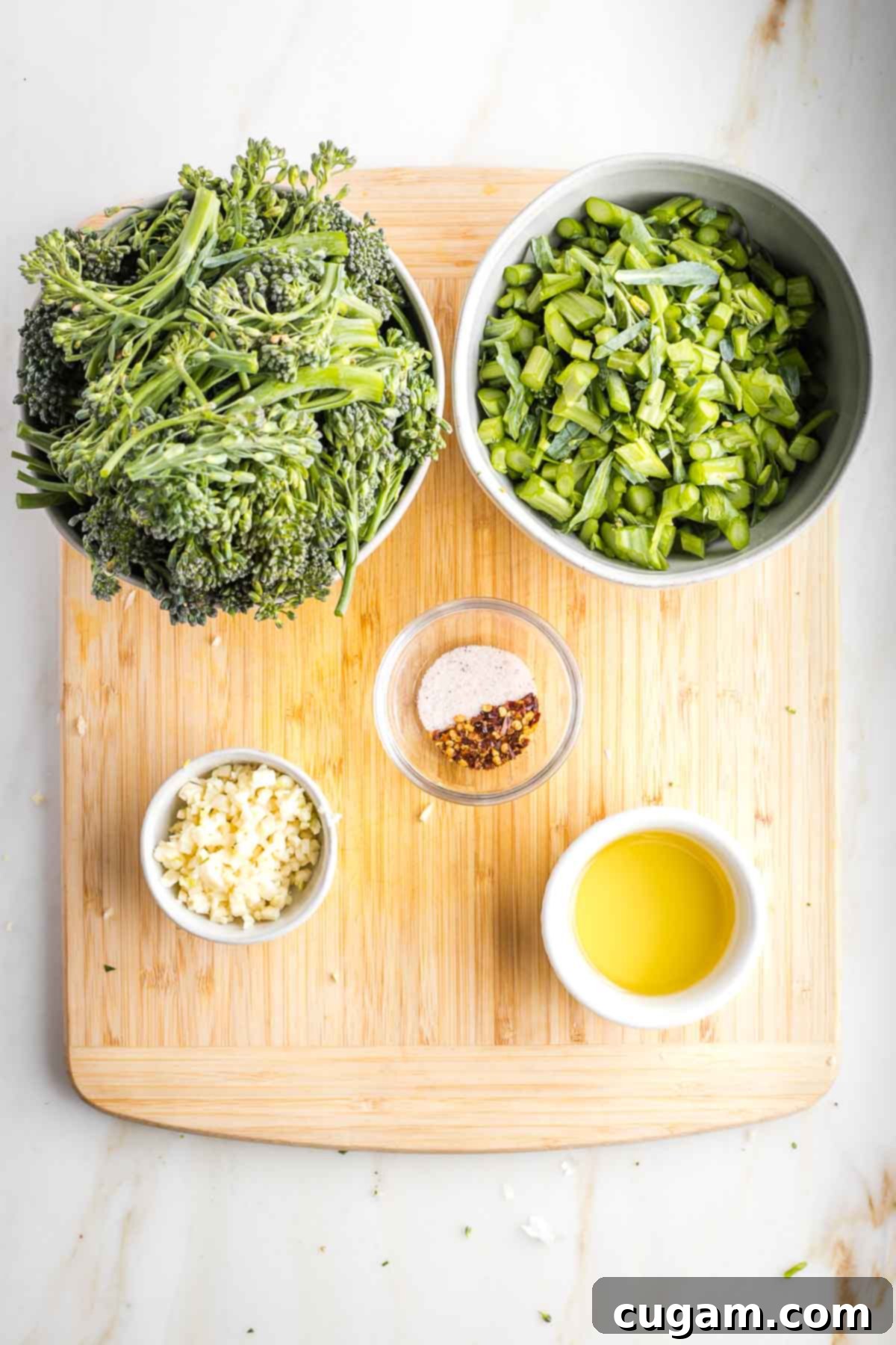 Prep bowls with trimmed broccolini, minced garlic, spices and oil.