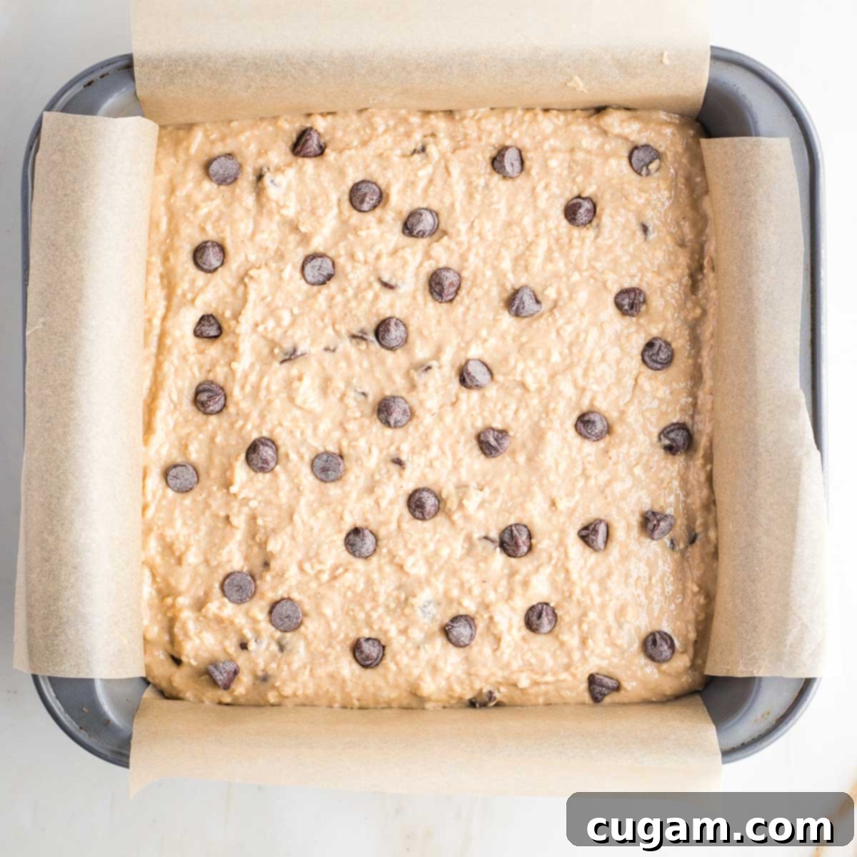 Square baking pan filled with blondies batter with chocolate chips. 