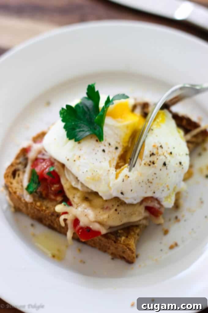Poached egg served on toasted bread with fresh tomatoes and grated Parmesan.