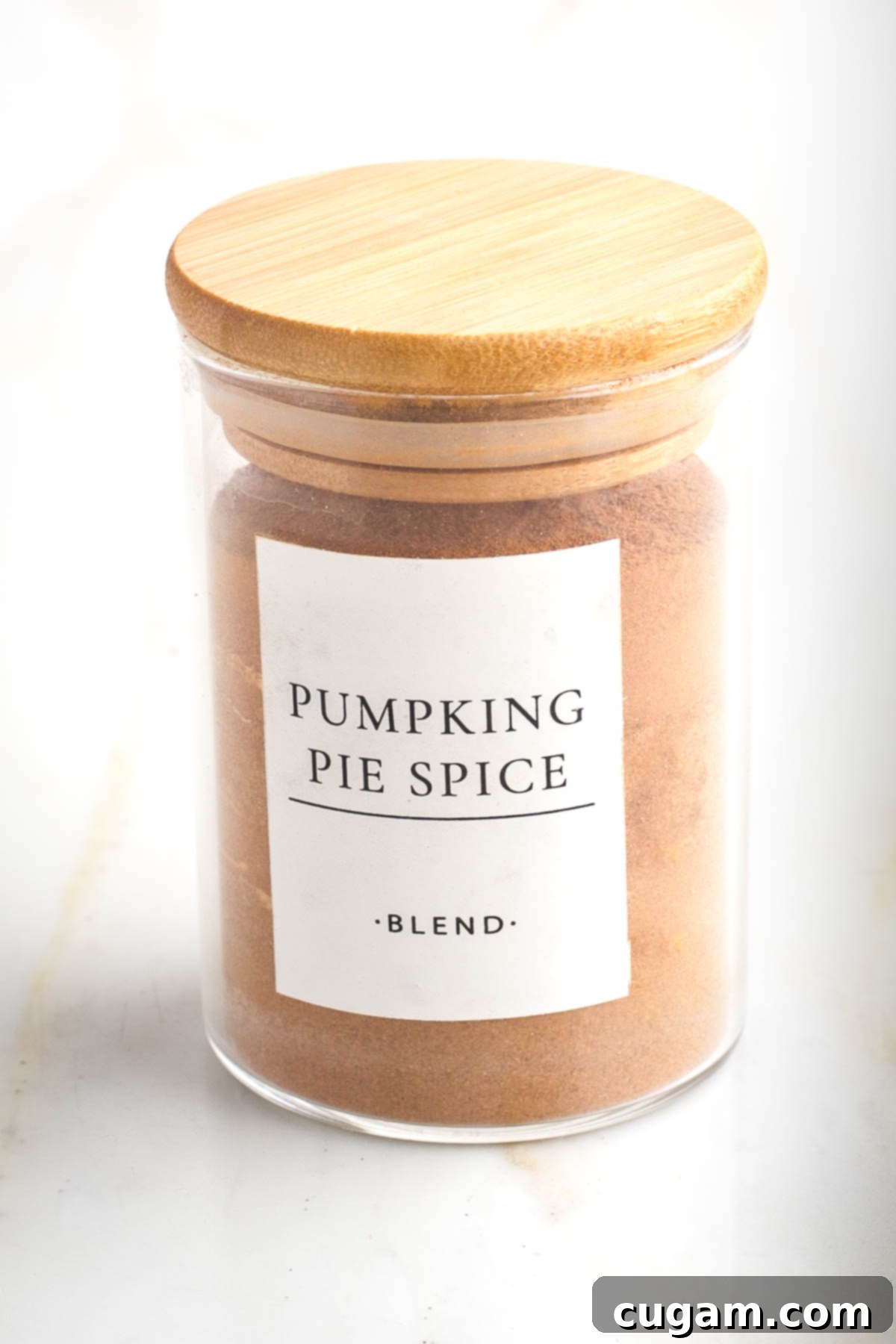 Small spice jar labeled "pumpkin pie spice blend" filled with a brownish-orange spice mixture.