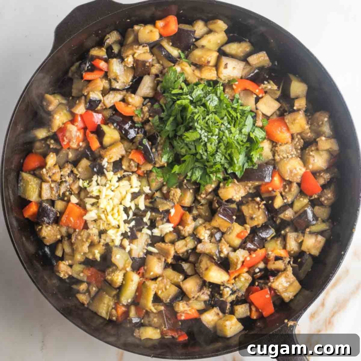 Pan-Fried Eggplant Salad 12 Sauteed eggplant and red peppers with a pile of freshly chopped parsley and some minced garlic on top, ready for final stir.