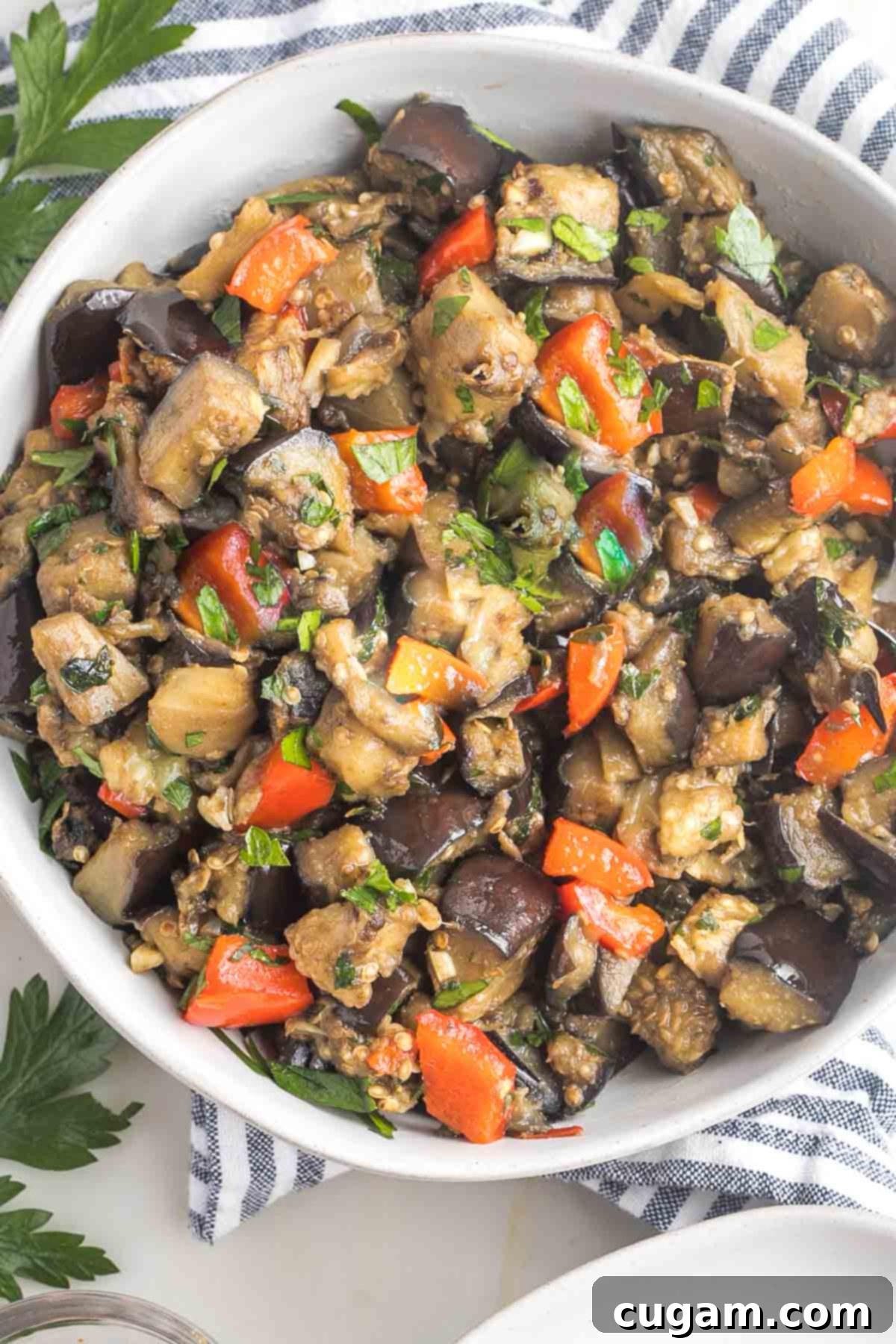 Pan-Fried Eggplant Salad 14 Bowl of eggplant salad featuring perfectly sautéed eggplant cubes, vibrant red pepper, aromatic garlic, and fresh parsley, ready to be served.