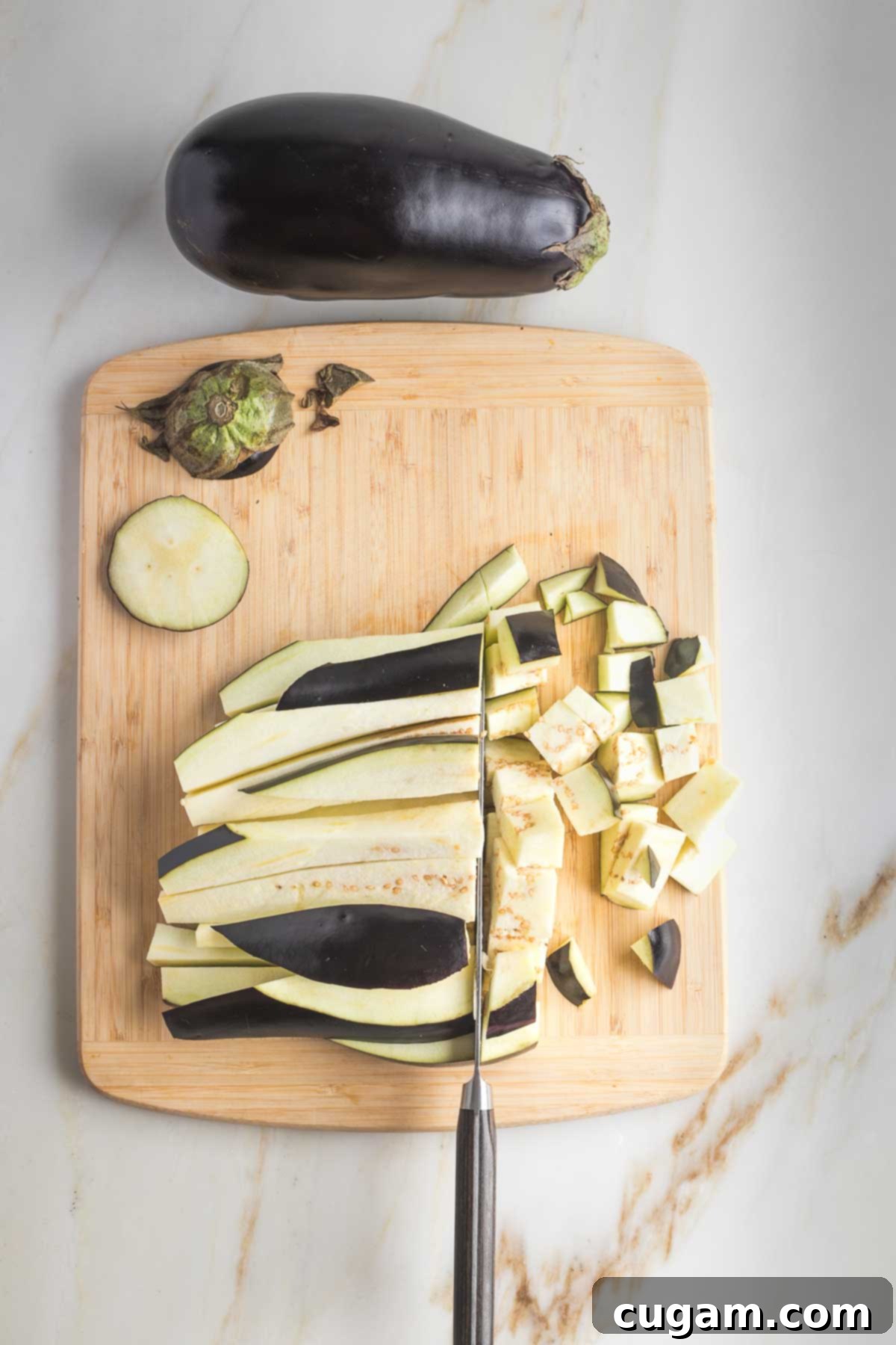 Pan-Fried Eggplant Salad 6 Eggplant strips being cut horizontally into small, uniform ½-inch cubes.