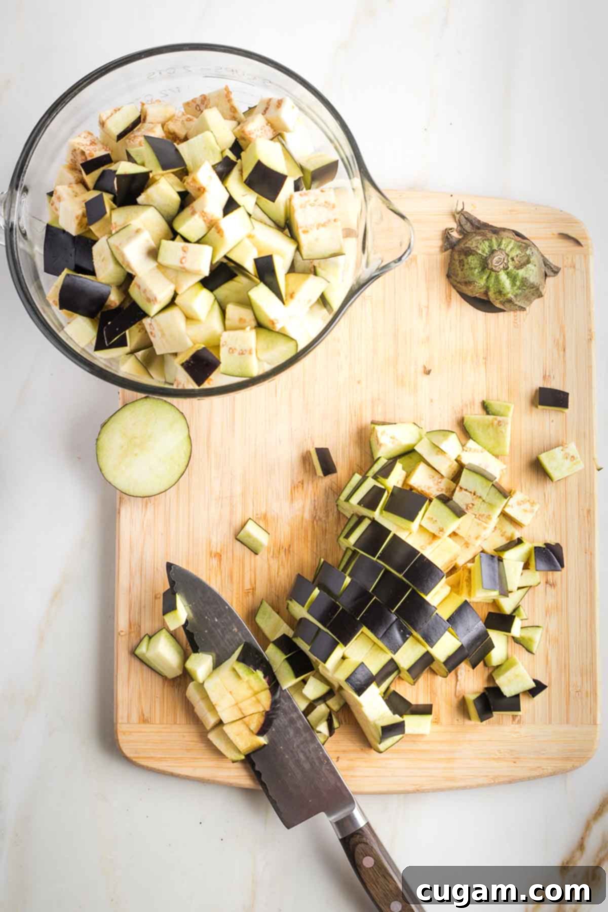 Pan-Fried Eggplant Salad 7 A large pile of freshly cut ½-inch eggplant cubes on a cutting board.