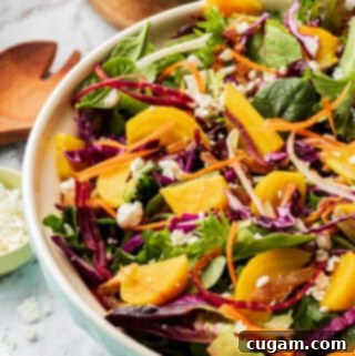 Golden Beet Salad with carrots and feta cheese in a blue bowl on marble.