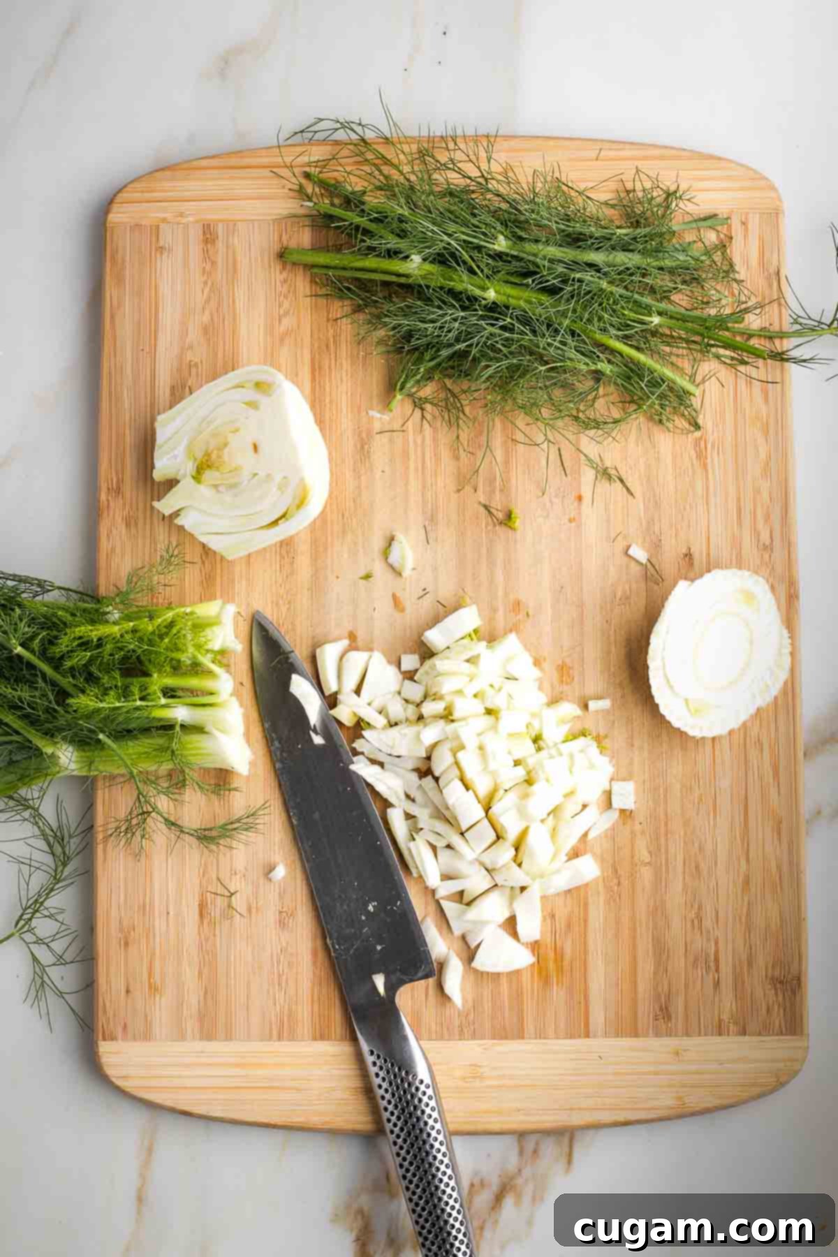 Fennel bulb being diced on a cutting board.