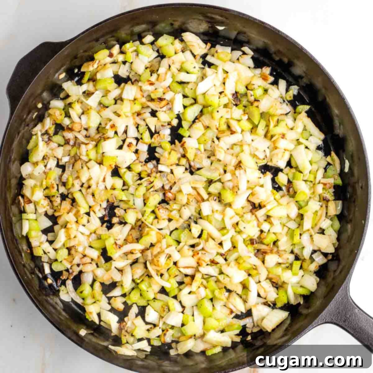 Browned bits of celery, onion and fennel in a cast iron skillet.