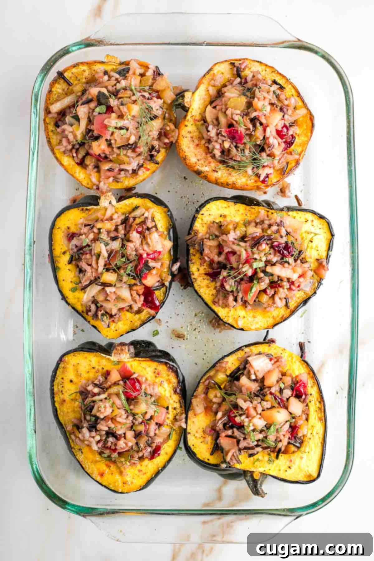 Halved acorn squash filled with vegan wild rice stuffing. 