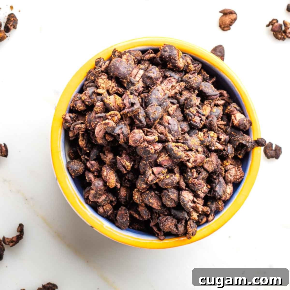 Yellow rimmed bowl filled with crunchy black bean snack.