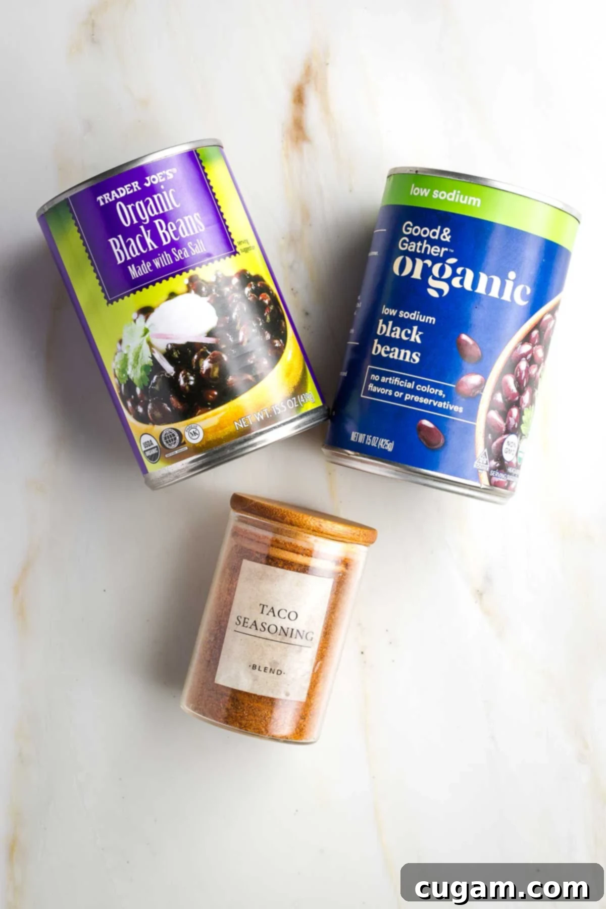 Two cans of black beans, one is low sodium, and a jar of No-salt taco seasoning. 