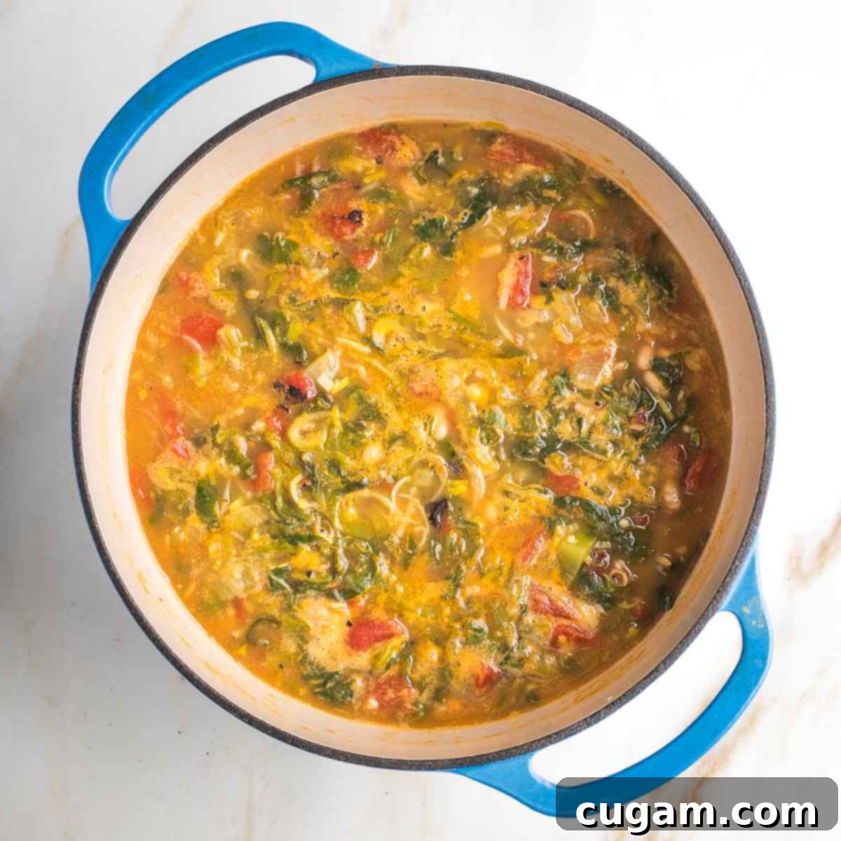 Cooked greens, tomatoes and beans in a thick broth. 