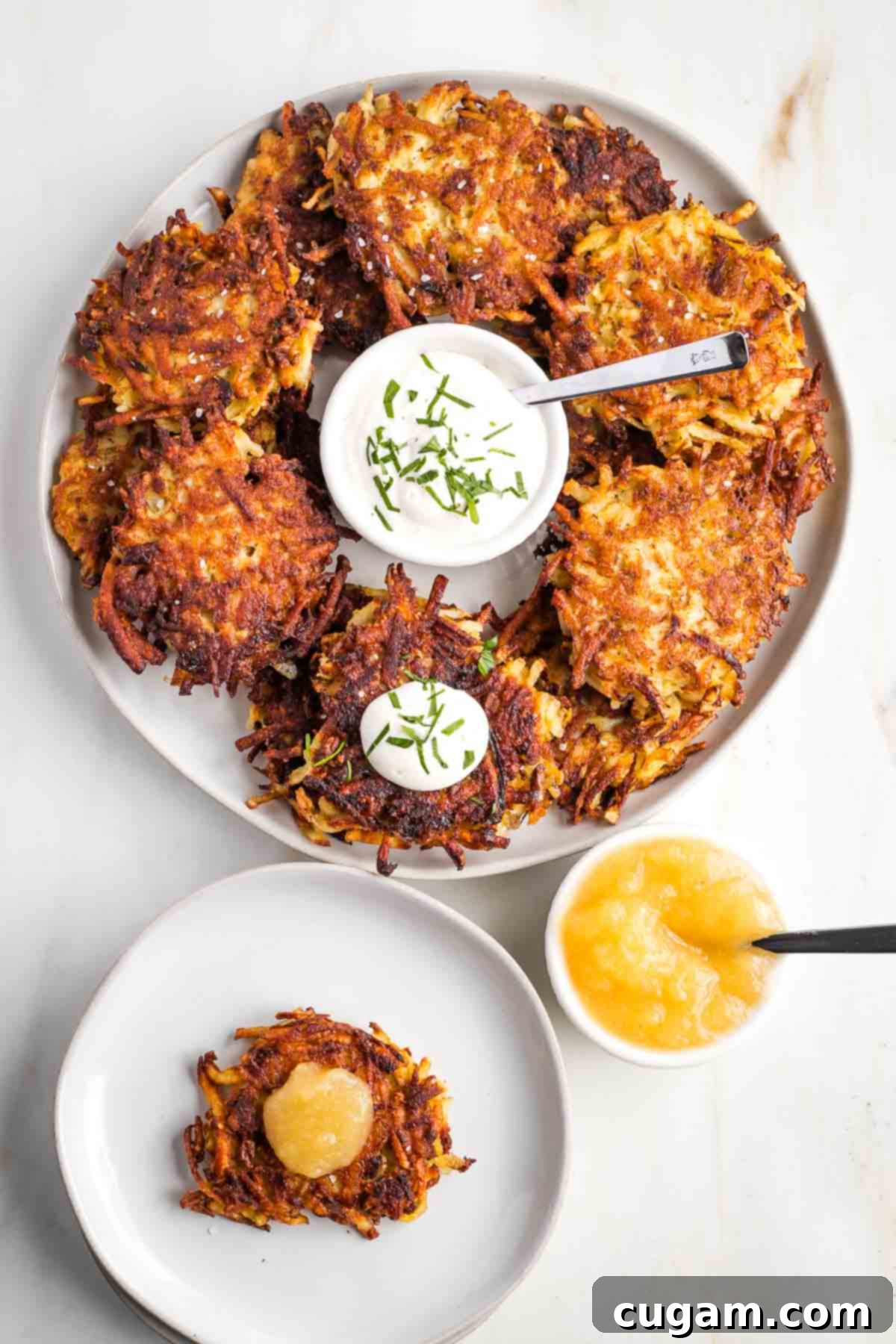 Grandma's Secret Potato Latkes 2 Plate of latkes with sour cream in the center, plus a small plate of one latka with applesauce.