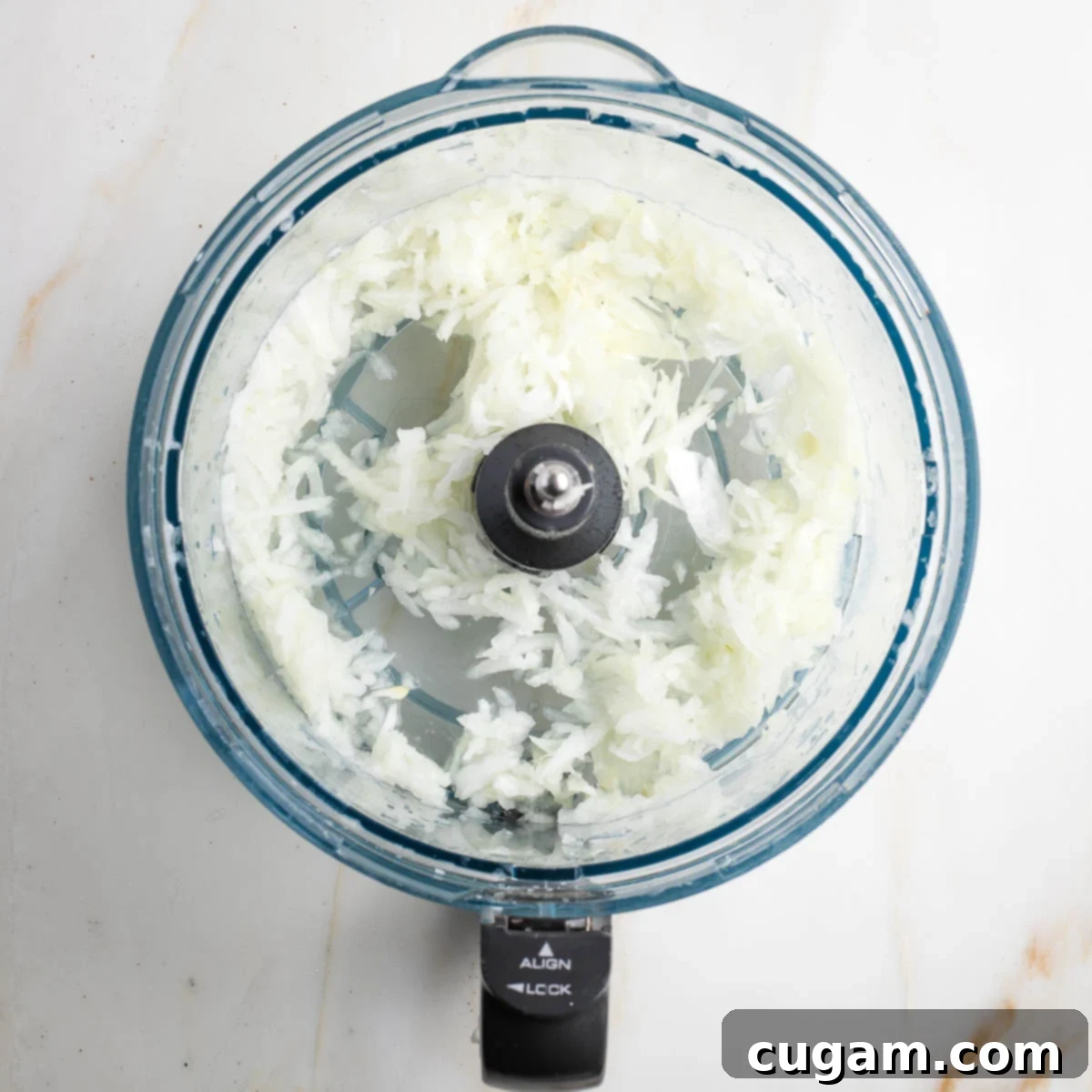 Grandma's Secret Potato Latkes 4 Shredded onions in a food processor bowl.