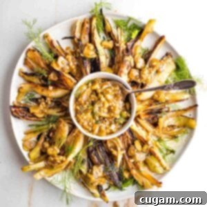 Braised fennel wedges on a plate with sauce in the middle.
