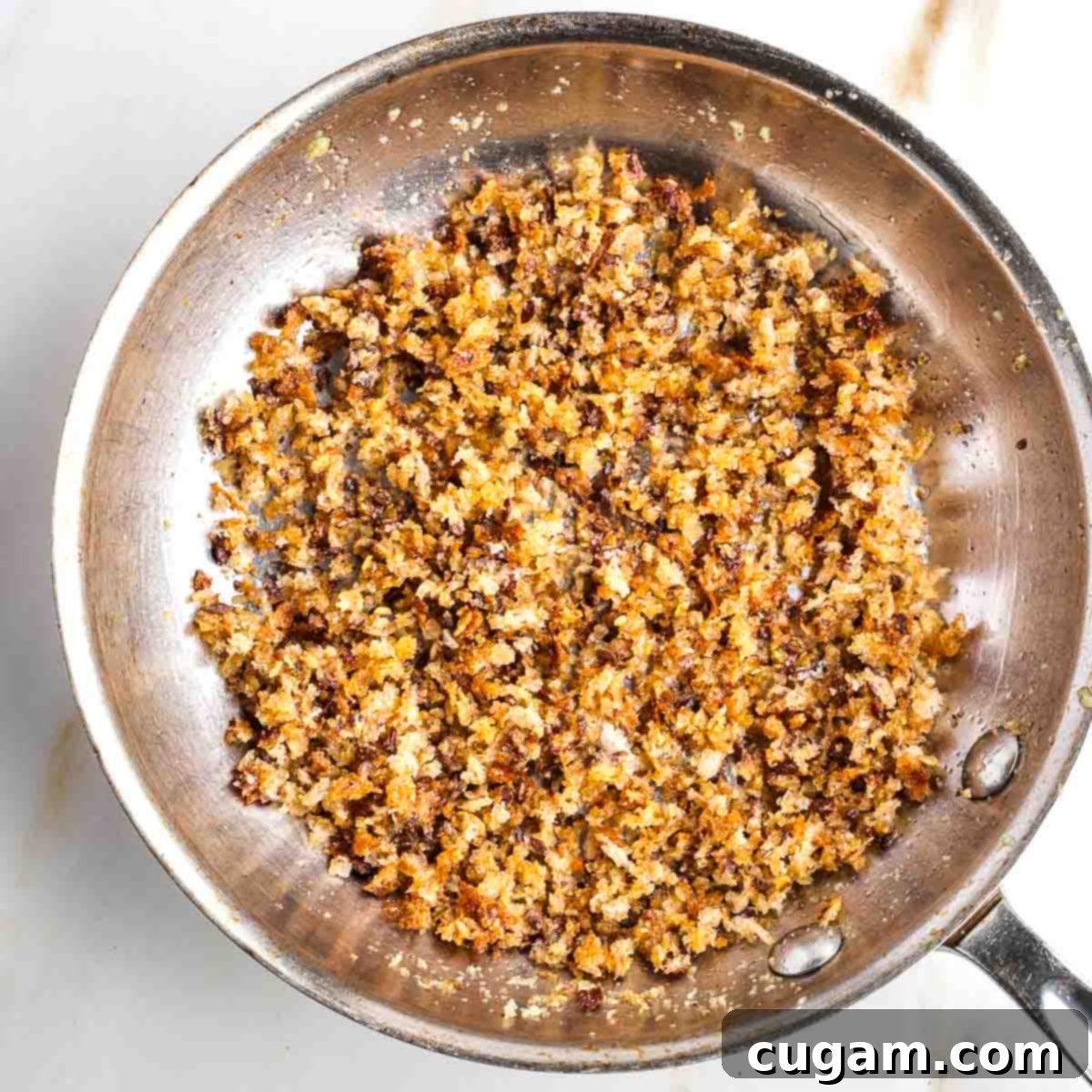 Small fry pan with toasted bread crumbs.