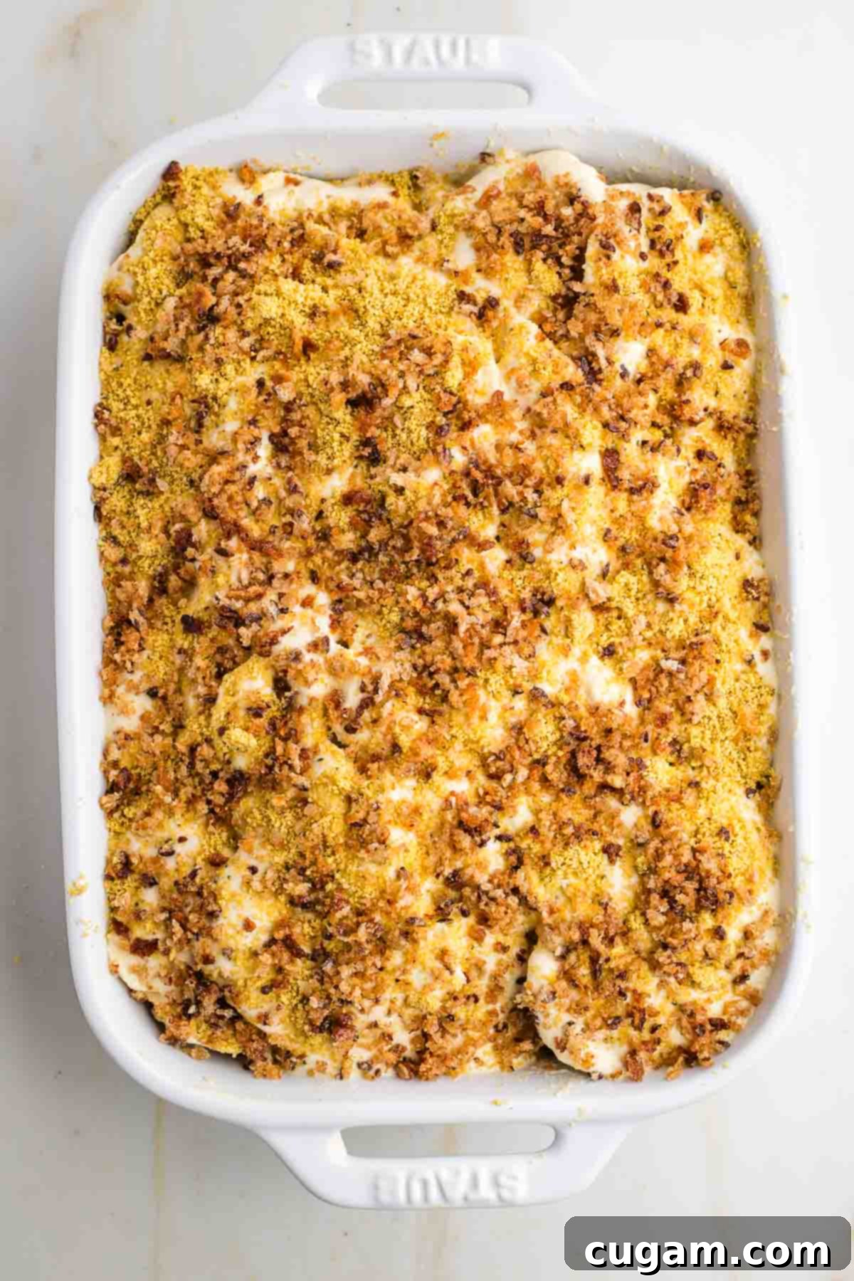 Parsnip gratin ready for oven with breadcrumbs on top.