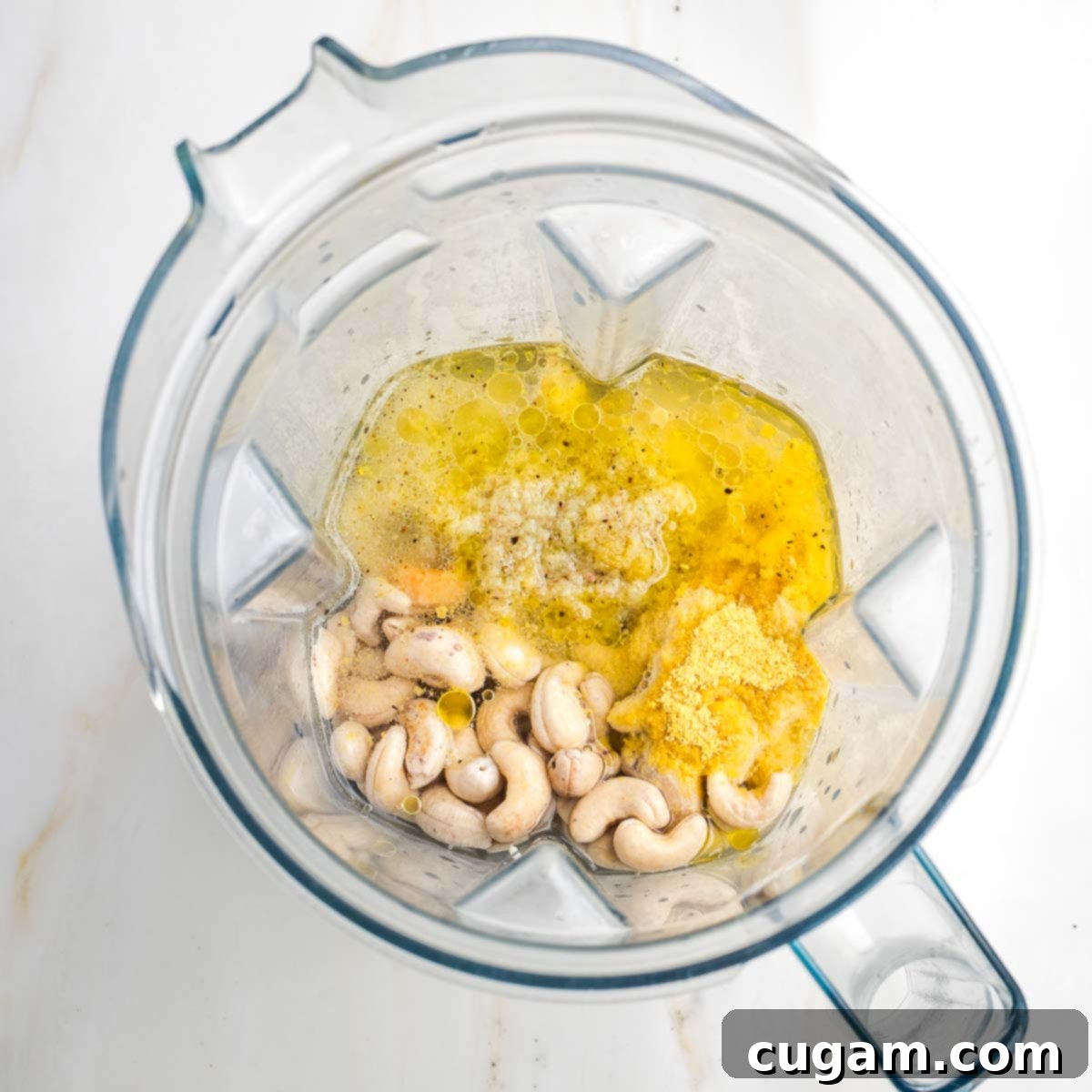 Blender with cashews, garlic, oil and nutritional yeast.