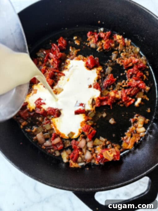 Adding heavy cream to the pan with sauteed vegetables and wine reduction