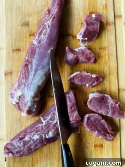 Cutting the pork medallions into slices on a chopping board